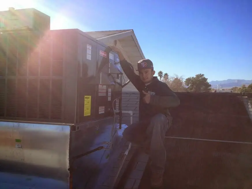 HVAC technician performing Air Duct Repair on a rooftop unit in Little Chute